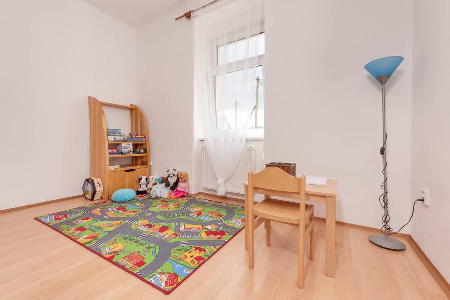 Dětský pokoj s kobercem s cestičkami, hračkami a stolečkem
